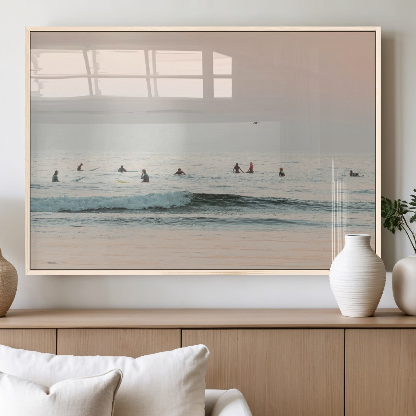 Dreamy photo of surfers waiting on soft pastel waves under a pink sunset sky, ideal for soft coastal minimalist or serene ocean-themed home decor.