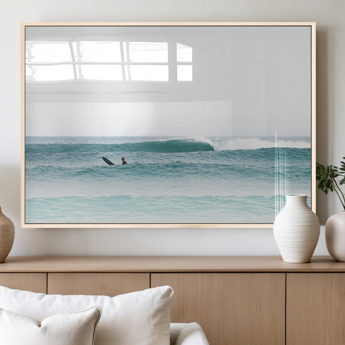Minimalist photo of a lone surfer on calm aqua waves under bright sky, perfect for Scandinavian coastal or serene ocean-inspired home decor.