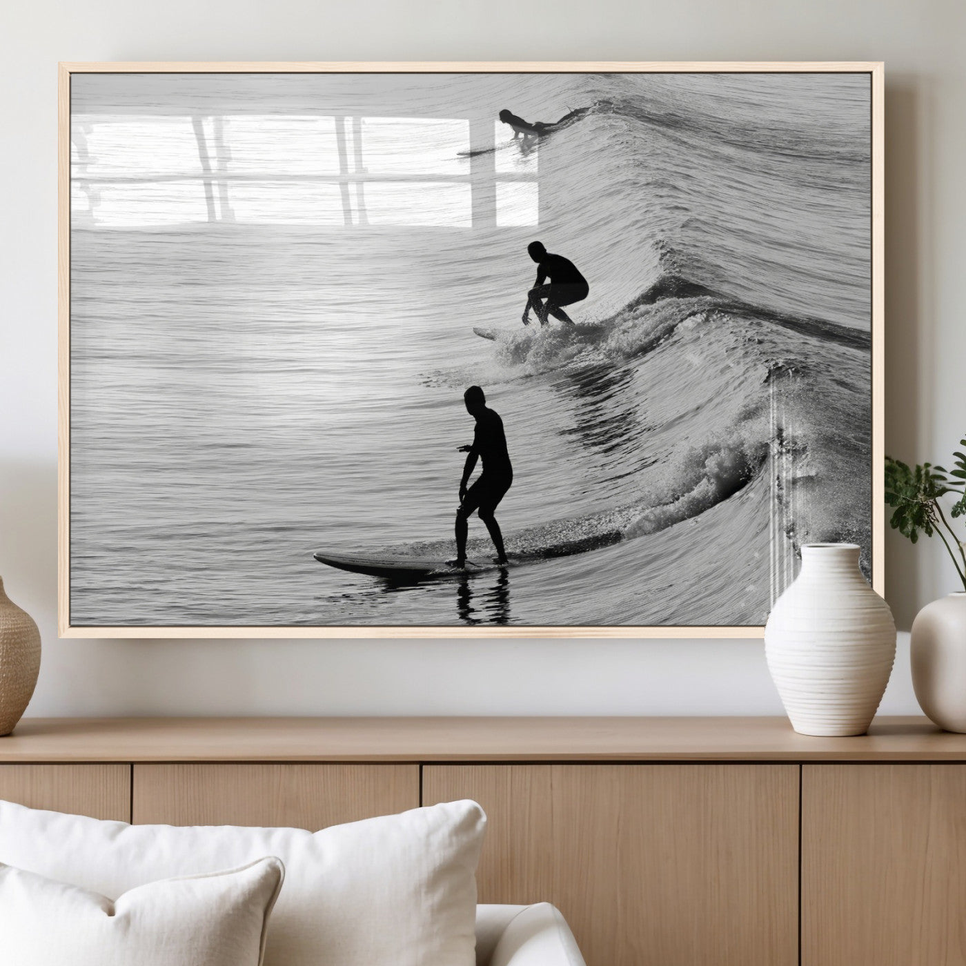 Black and white photo of surfers riding waves in a moody, high-contrast scene, ideal for modern coastal or surf-inspired home decor.