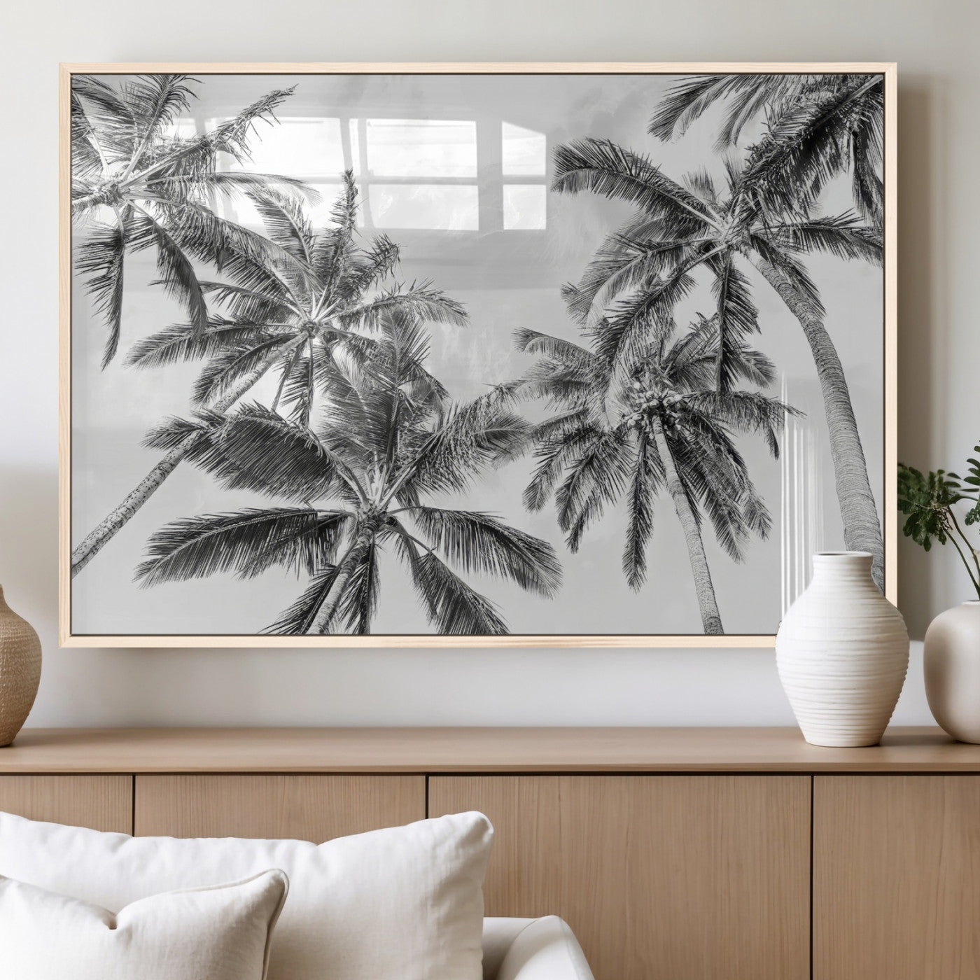 Black and white tropical palm trees viewed from below, swaying gently against a bright sky, creating a serene and elegant coastal atmosphere.