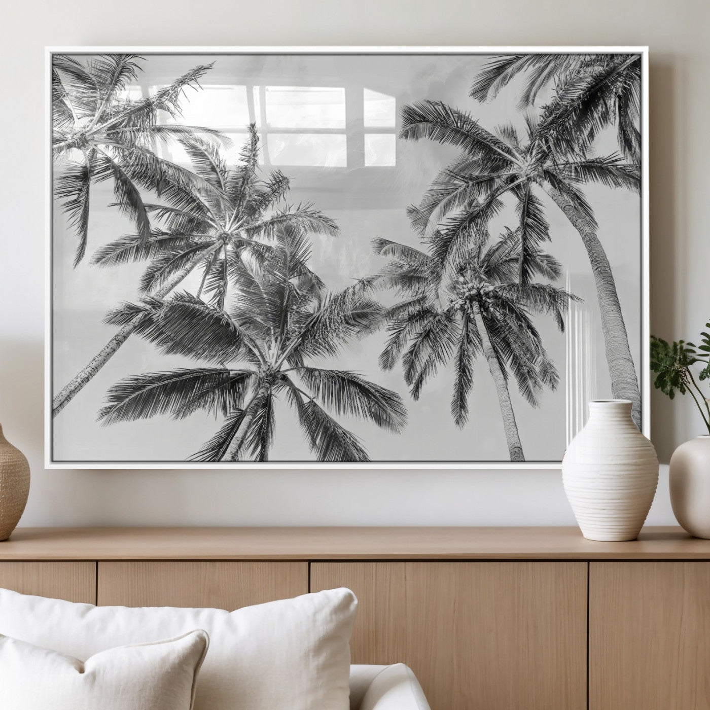Black and white tropical palm trees viewed from below, swaying gently against a bright sky, creating a serene and elegant coastal atmosphere.