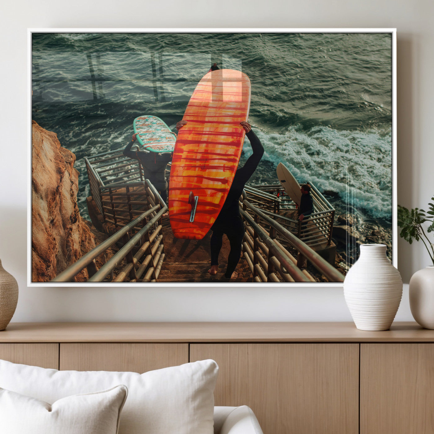 A surfer carrying a bold orange surfboard down a rugged staircase toward the ocean, bathed in golden hour light, capturing the energy of coastal adventure.