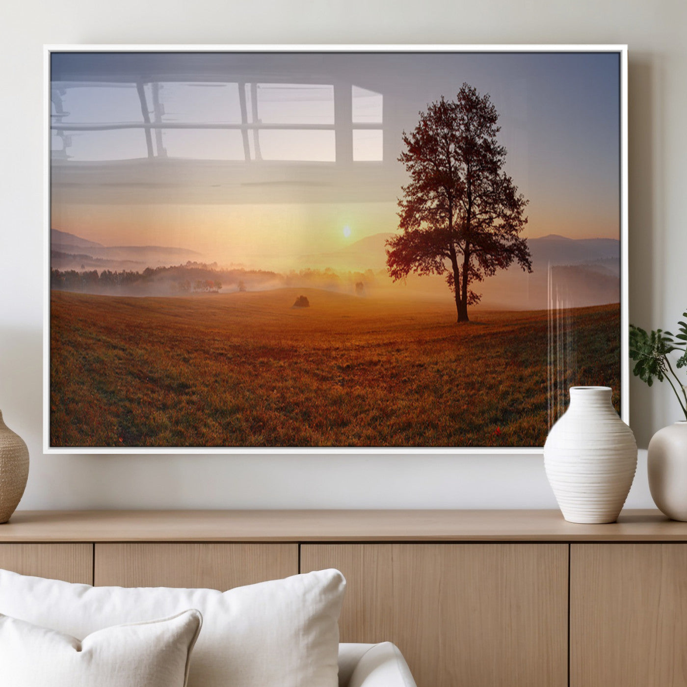 A tranquil landscape at sunrise with a mist-covered field and a lone tree, creating a peaceful and natural atmosphere.