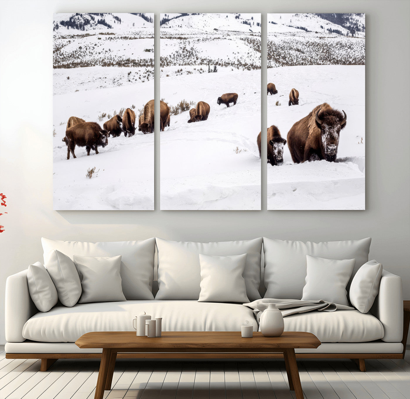 A herd of bison walking through deep snow in a mountain valley, perfect for rustic, cabin or western-themed wall decor.