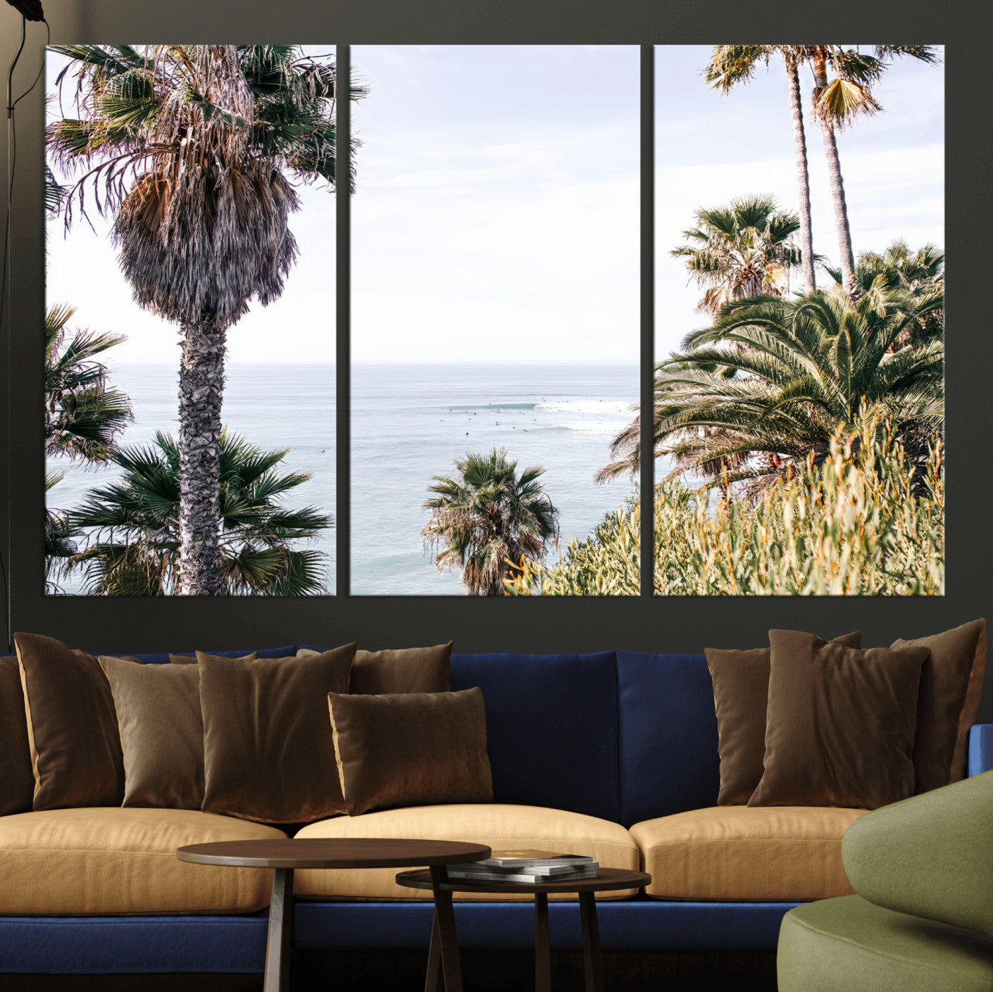 Scenic coastal view with tall palm trees overlooking a calm ocean, soft blue waves, and surfers in the distance, creating a peaceful tropical vibe.