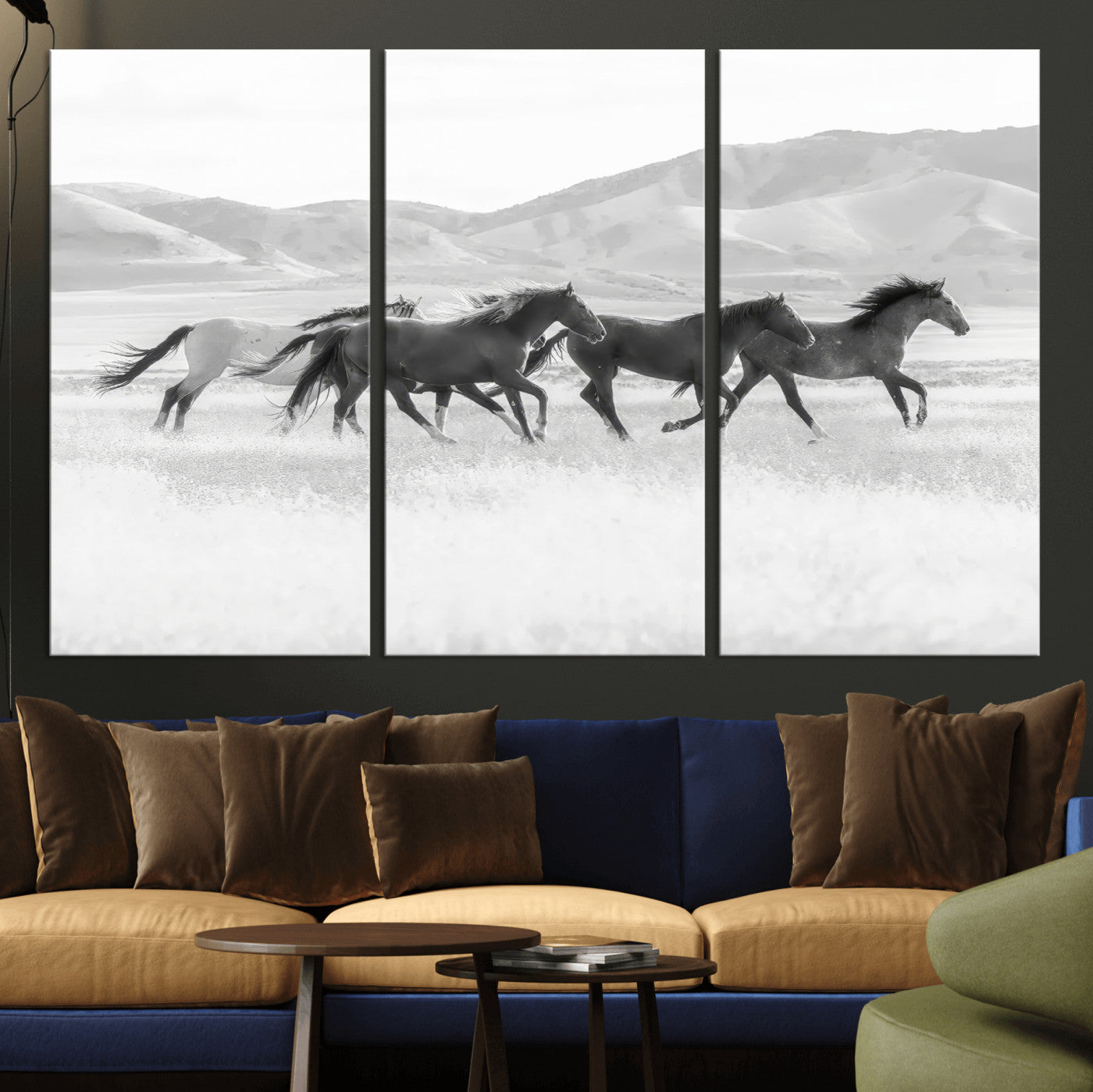 A black and white image of wild horses running freely across an open grassland, capturing the power and beauty of untamed nature in a rustic western setting.