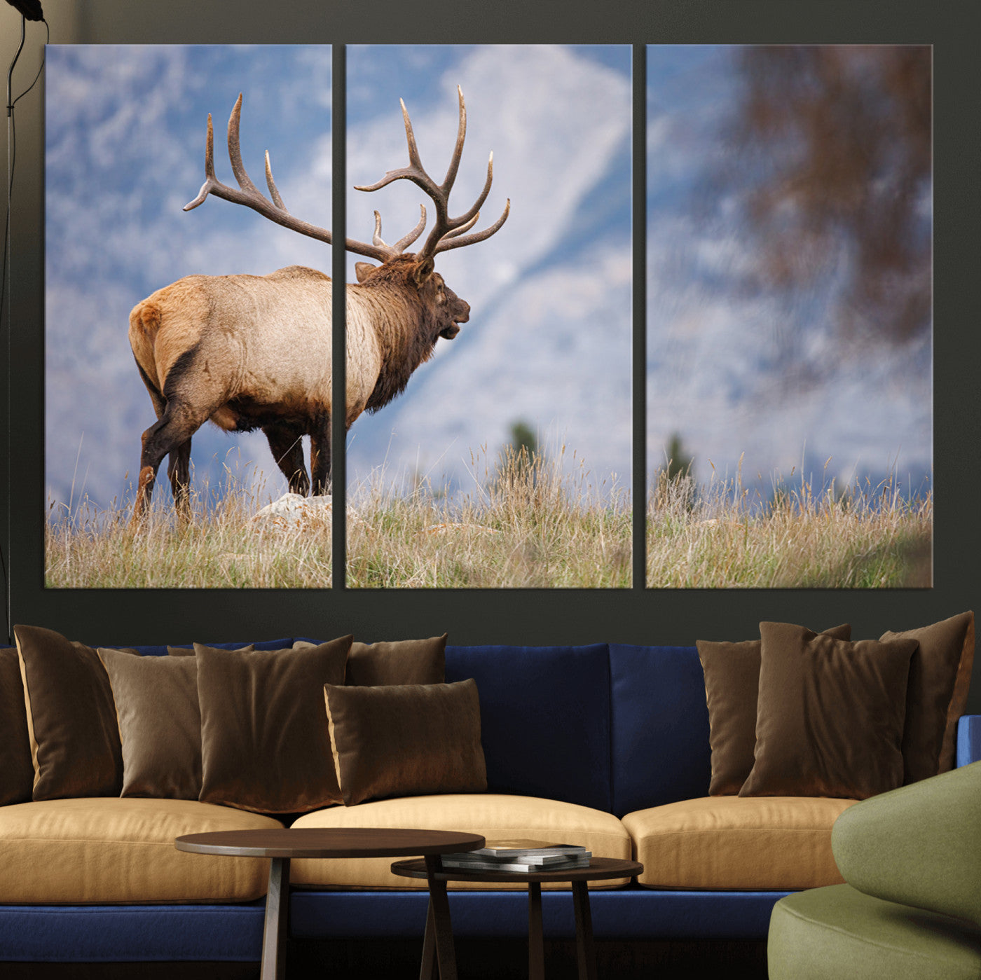 Elk with antlers standing on grass with mountain background, ideal for rustic, cabin, or lodge-inspired wall decor.