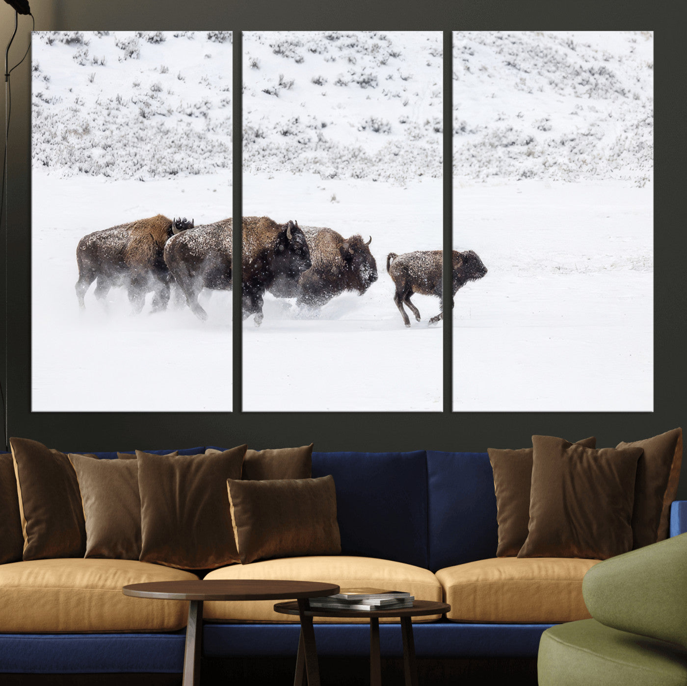 Bison herd running through a snowy open field with mountain backdrop, perfect for rustic or western-themed wall decoration.