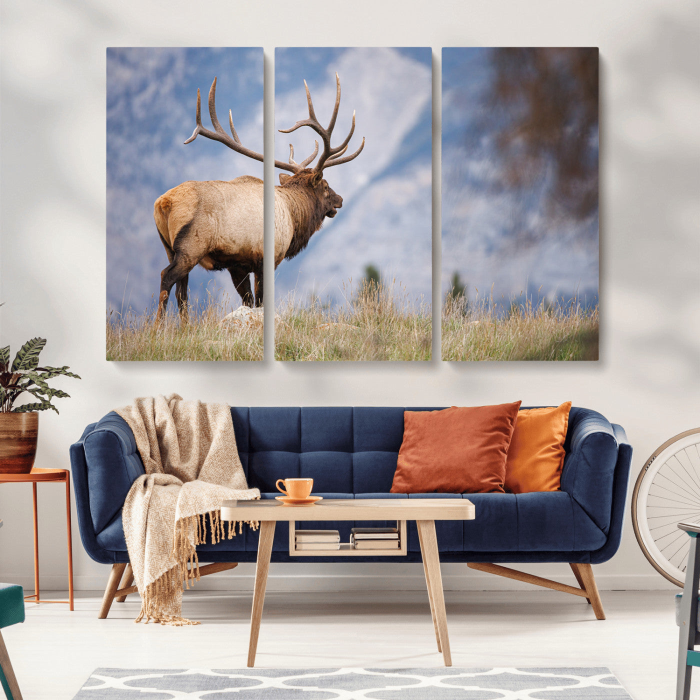 Elk with antlers standing on grass with mountain background, ideal for rustic, cabin, or lodge-inspired wall decor.