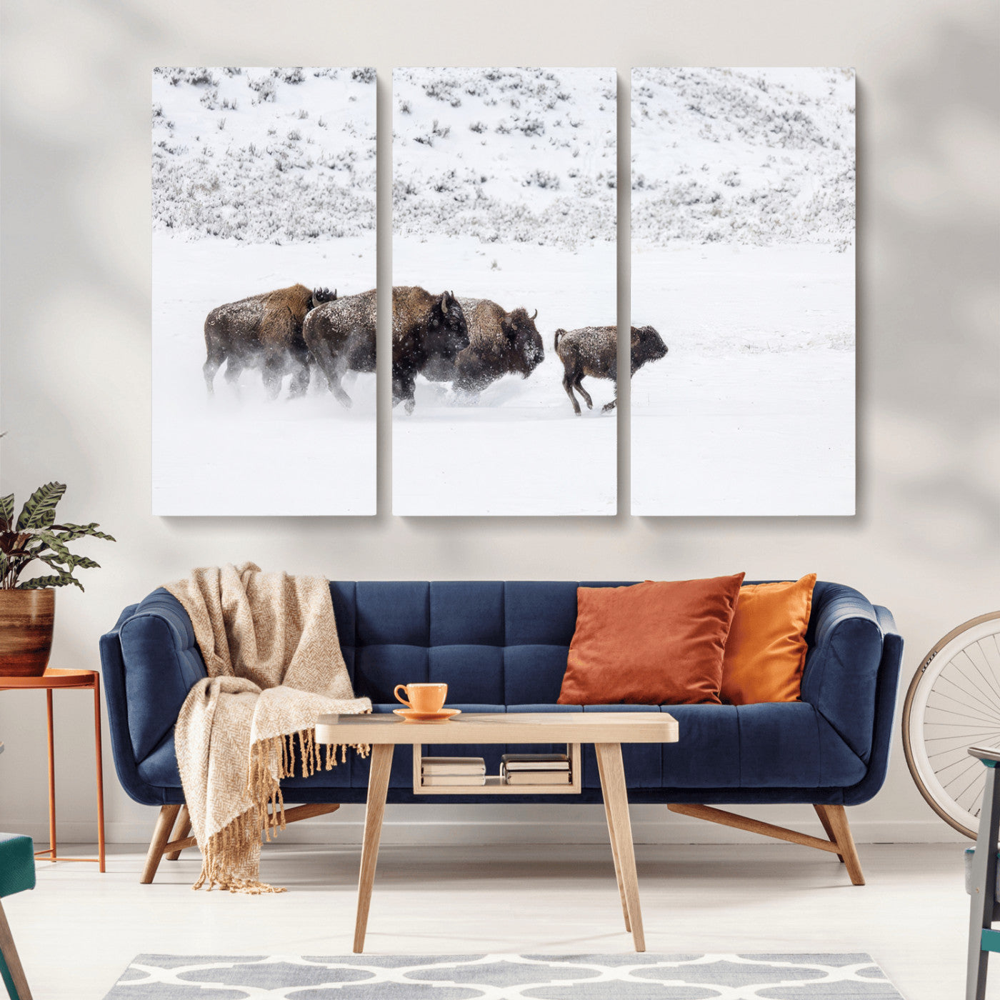 Bison herd running through a snowy open field with mountain backdrop, perfect for rustic or western-themed wall decoration.