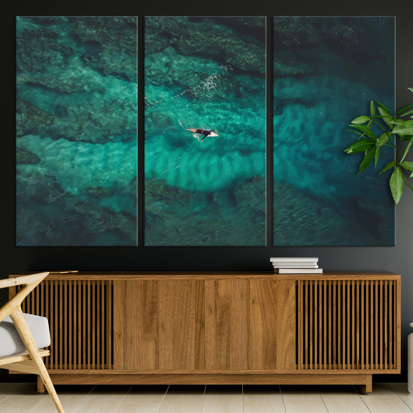 An aerial view of a solo surfer paddling through crystal-clear turquoise waters over a sunlit reef, capturing the beauty and serenity of open water surfing.