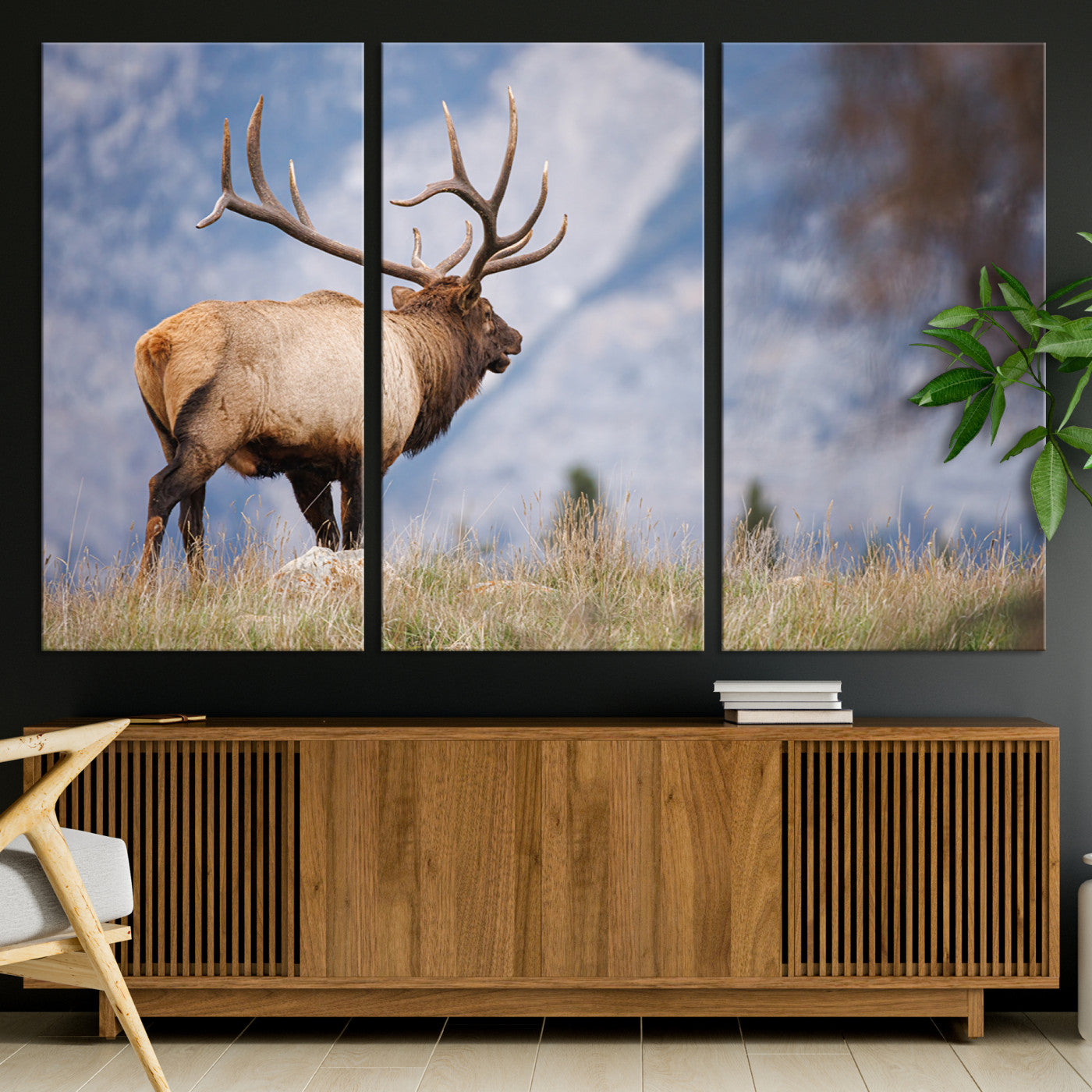 Elk with antlers standing on grass with mountain background, ideal for rustic, cabin, or lodge-inspired wall decor.