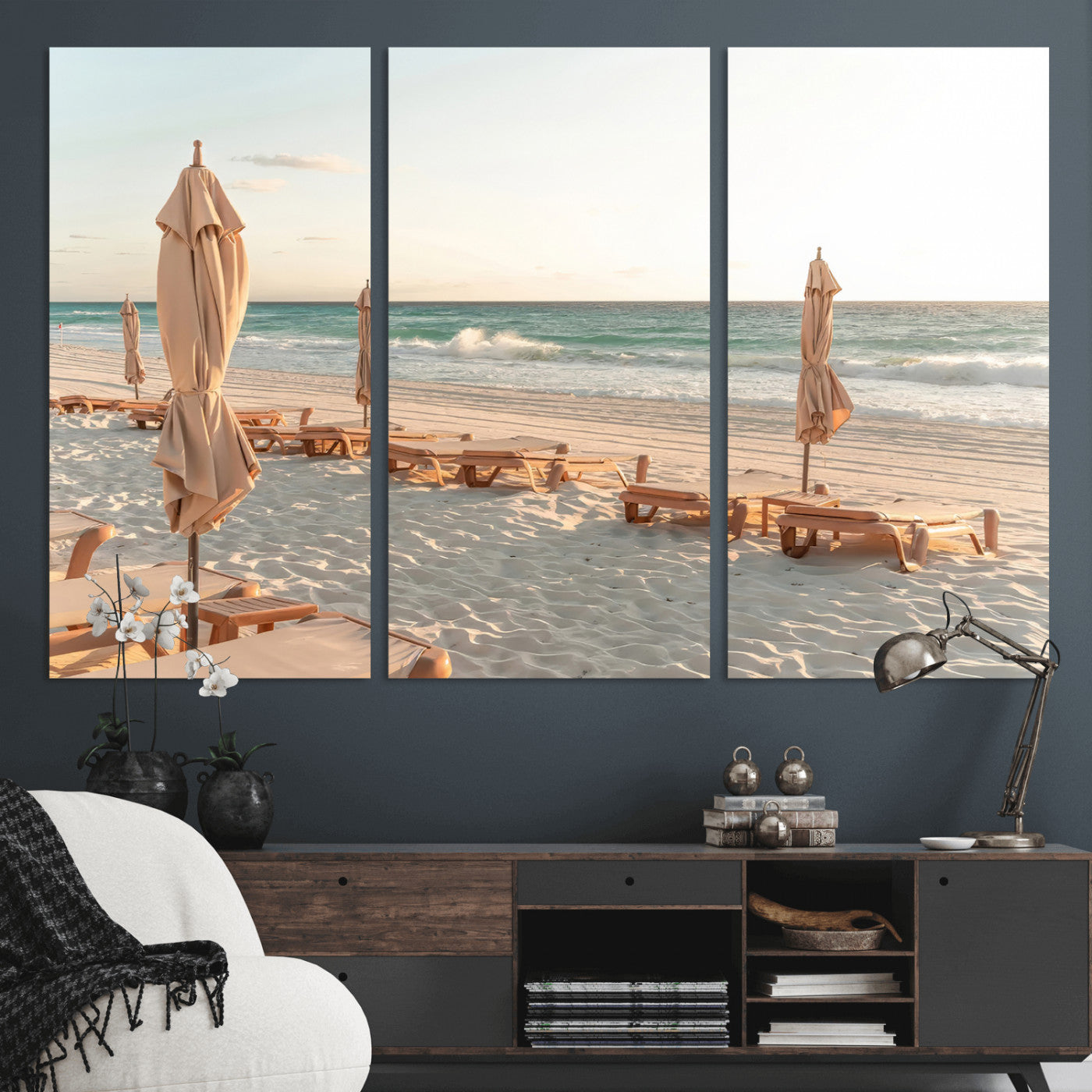 Minimalist photo of empty beach loungers and umbrellas on soft sand, ideal for calm seaside or pastel coastal-style home decor.