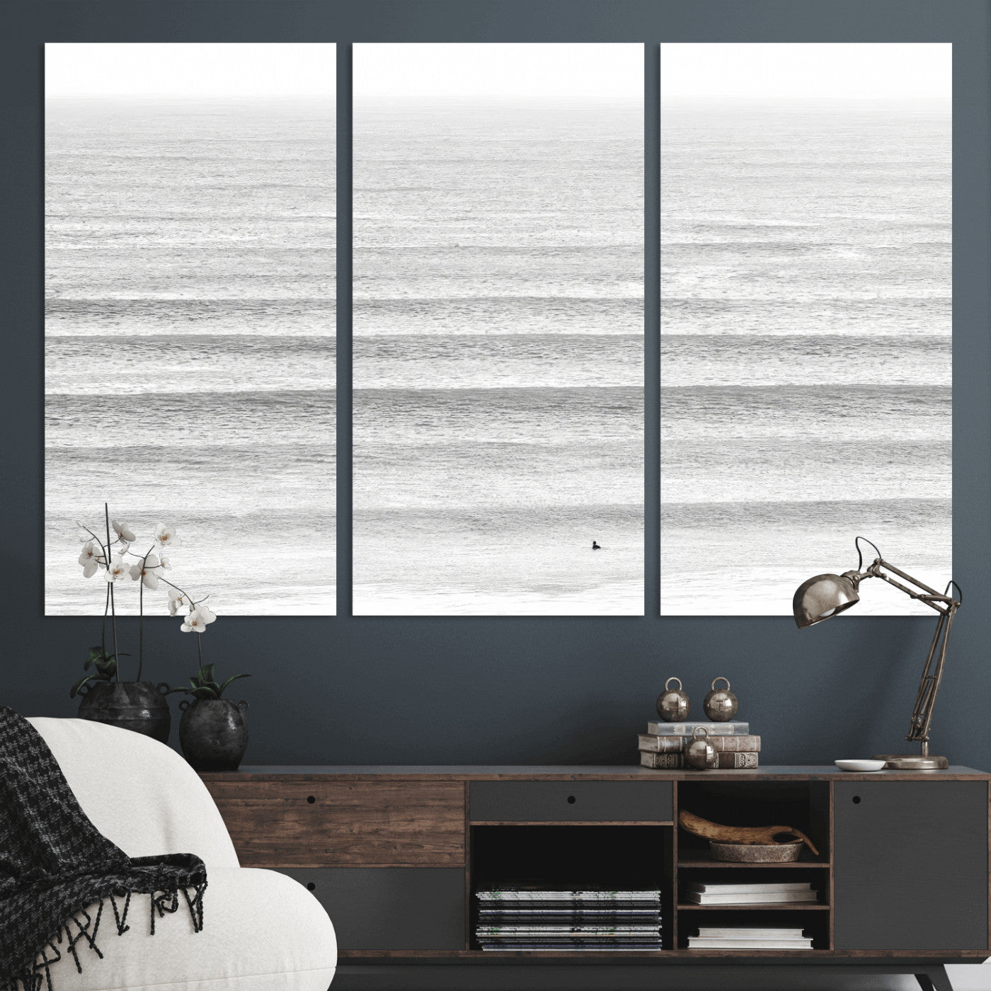 Monochrome photo of a lone surfer in calm layered waves, perfect for minimalist coastal or moody ocean-inspired wall decoration.