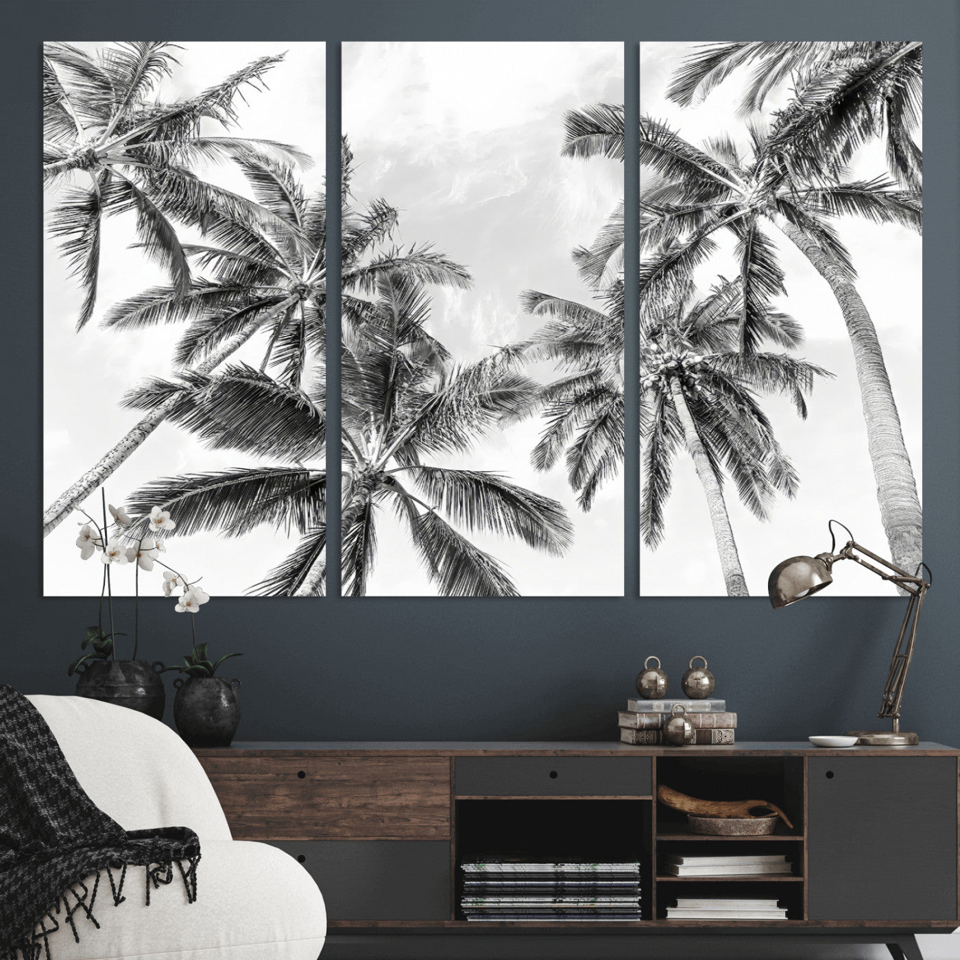 Black and white tropical palm trees viewed from below, swaying gently against a bright sky, creating a serene and elegant coastal atmosphere.