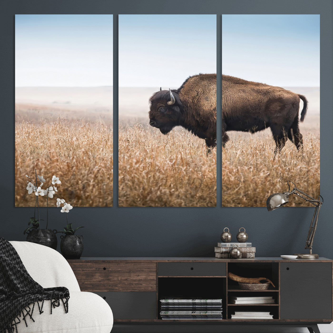 A majestic bison standing in an open prairie field, its strong form blending into the golden grass under a vast blue sky, evoking the wild spirit of the American plains.