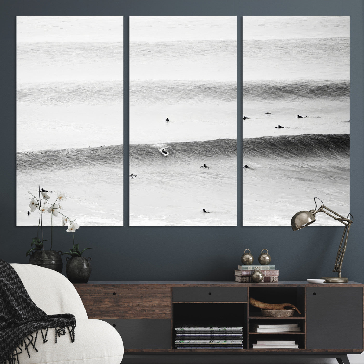 A monochrome photograph of swimmers gliding through gentle ocean waves, evoking a sense of calm and movement.