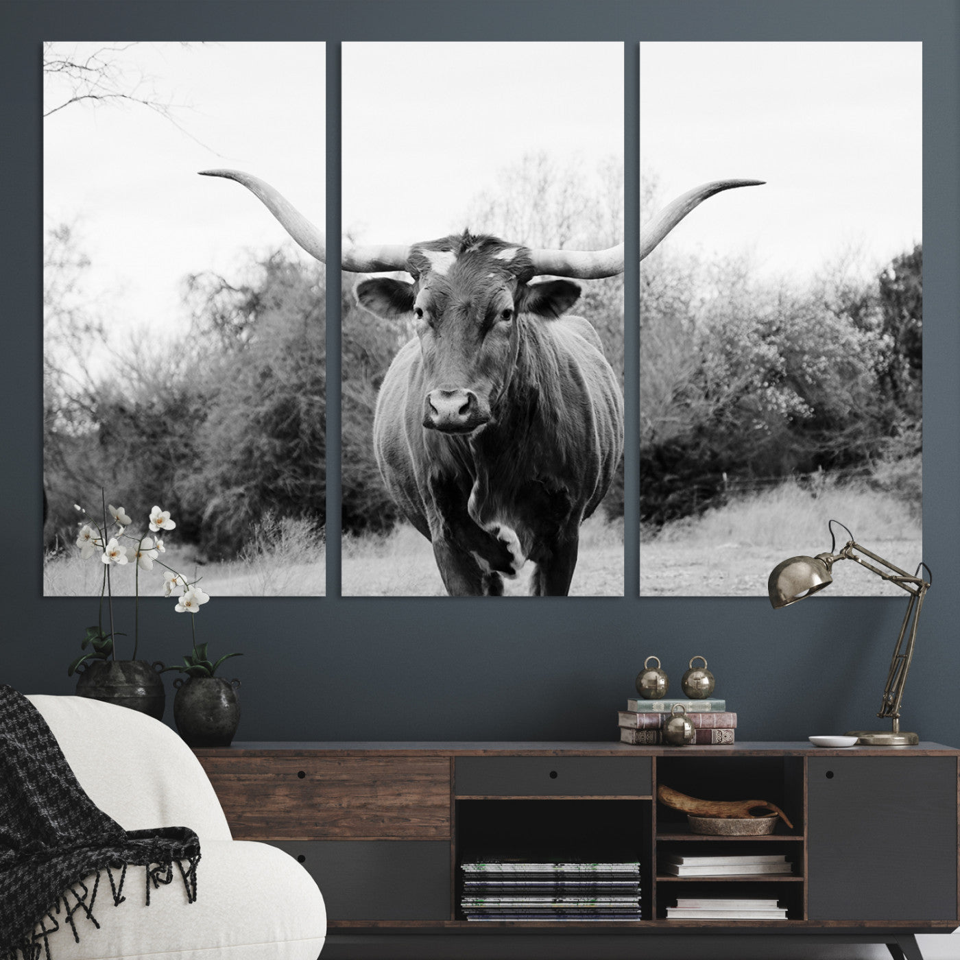 Black and white photo of a longhorn cow in a field, perfect for rustic farmhouse or western-themed interior wall decoration.