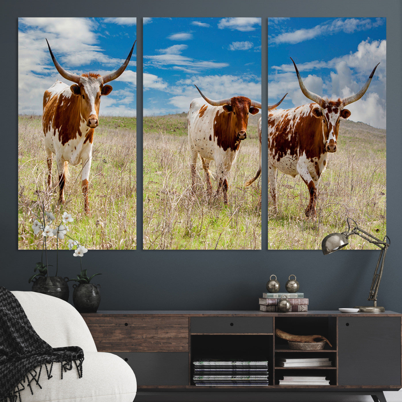 Three Texas longhorn cattle standing in dry grass under a bright blue sky, ideal for farmhouse or western rustic home decor.