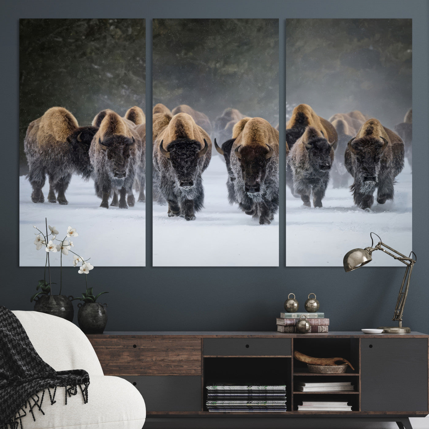 A herd of American bisons walking through deep snow in a forest, evoking a powerful rustic wilderness mood for western-style interiors.