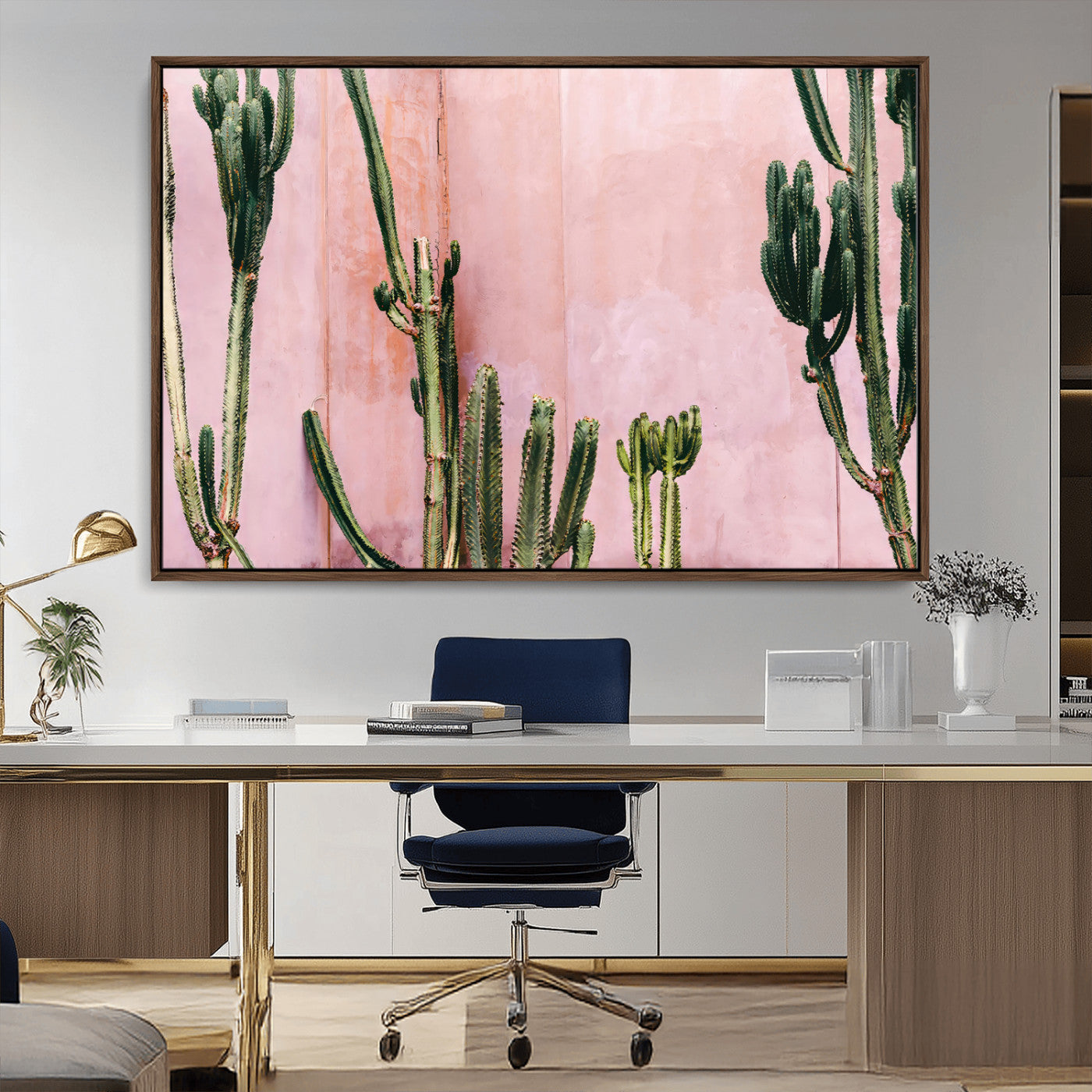 Framed canvas of tall green cacti against a soft pink wall, ideal for modern desert or colorful southwest-inspired home decor.