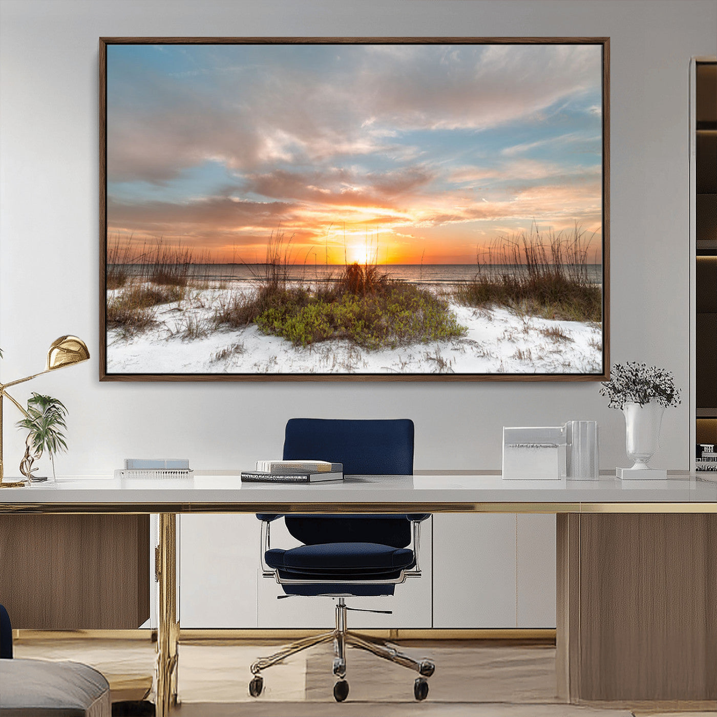 A tranquil beach scene featuring golden sunset hues over the water, with grasses in the foreground and a peaceful, serene atmosphere.