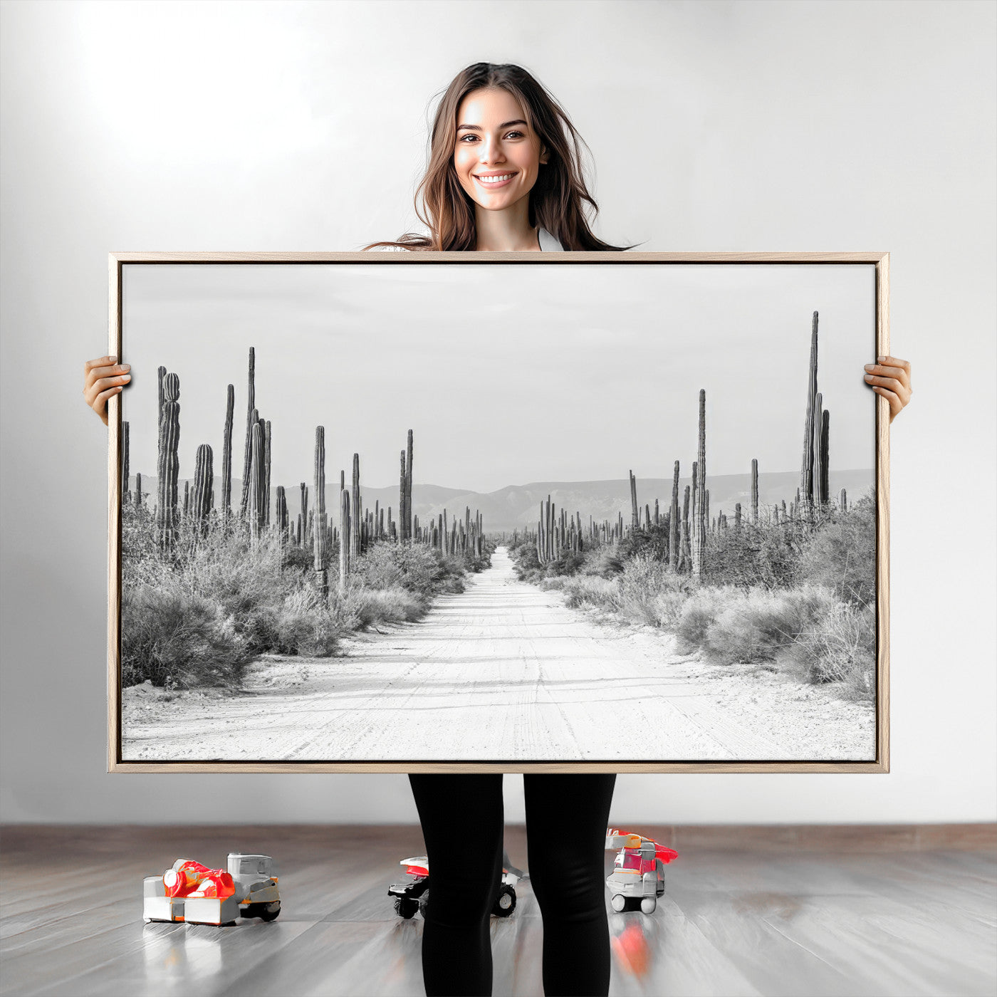 A black and white desert road stretching through a cactus-filled landscape, creating a rugged and timeless southwestern aesthetic with a sense of adventure.