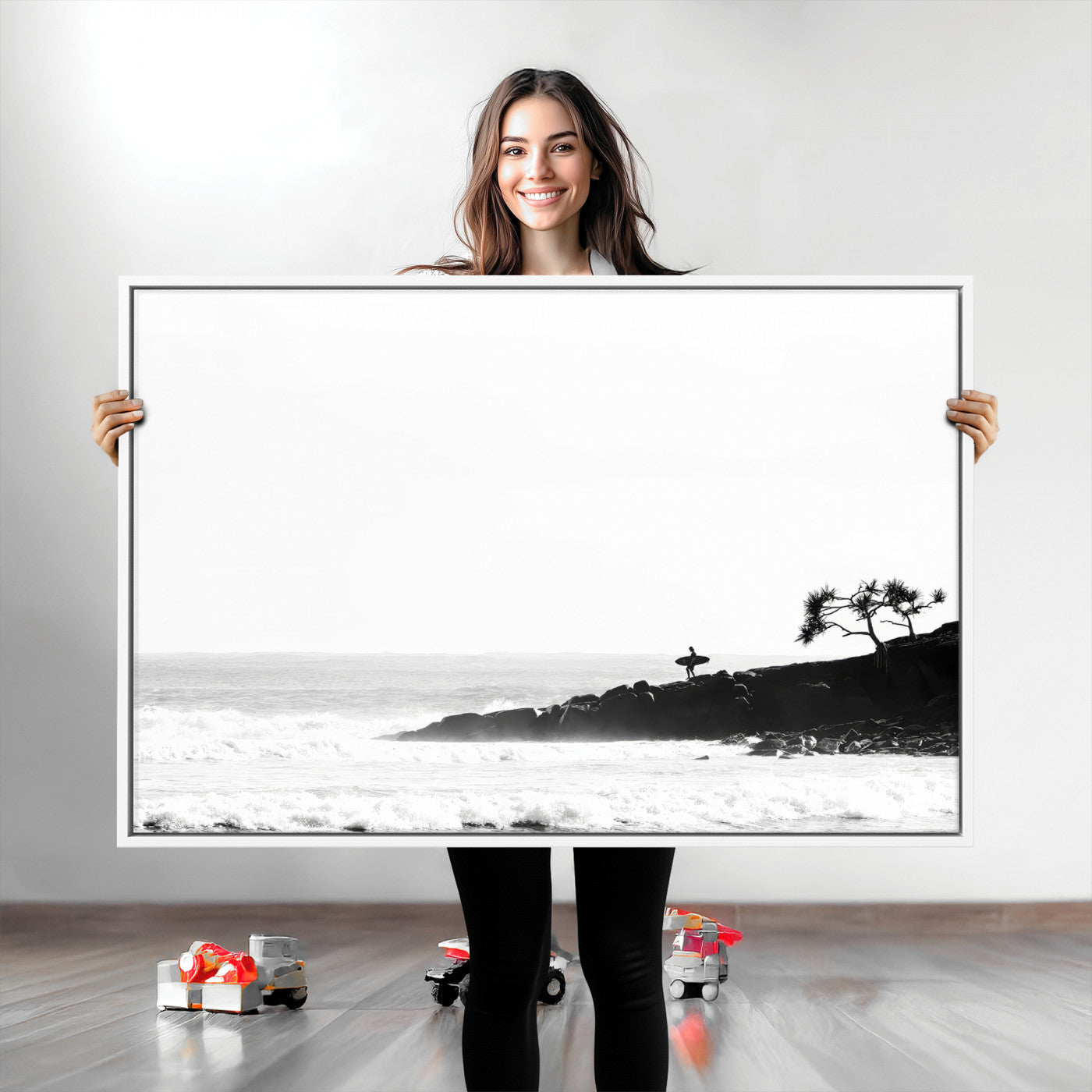 Black and white photo of a surfer standing on rocky cliffs, gazing at the waves, embodying the spirit of adventure and solitude.
