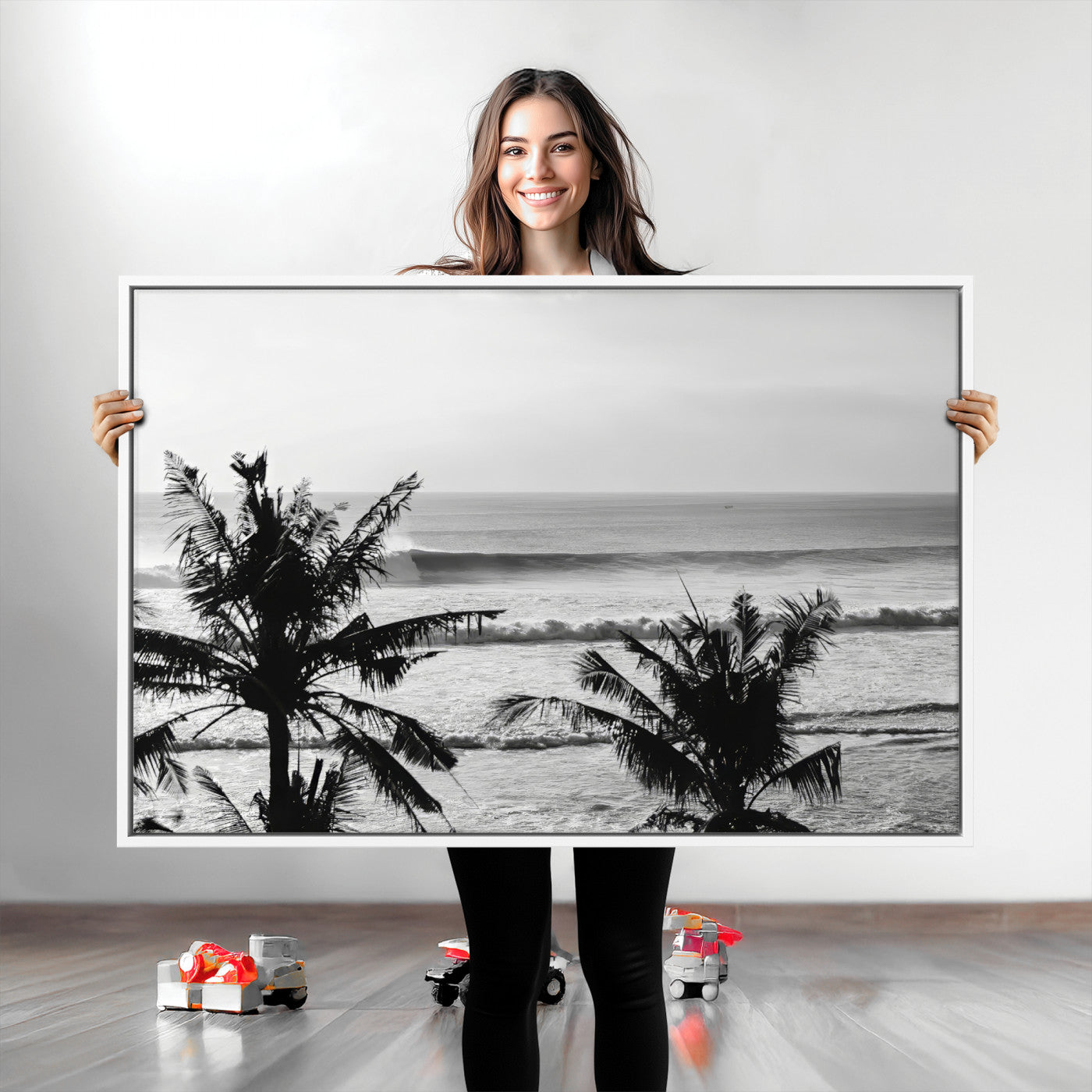 Black and white view of ocean waves crashing on a tropical coastline, framed by silhouetted palm trees under a vast, open sky.