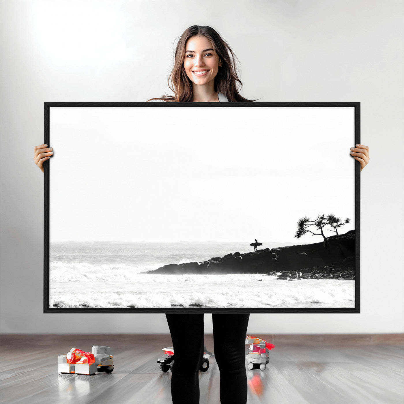Black and white photo of a surfer standing on rocky cliffs, gazing at the waves, embodying the spirit of adventure and solitude.