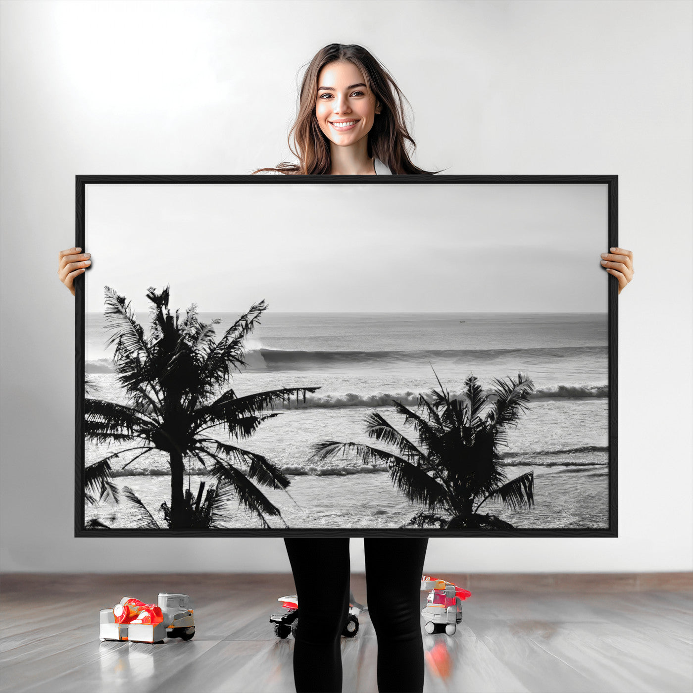 Black and white view of ocean waves crashing on a tropical coastline, framed by silhouetted palm trees under a vast, open sky.