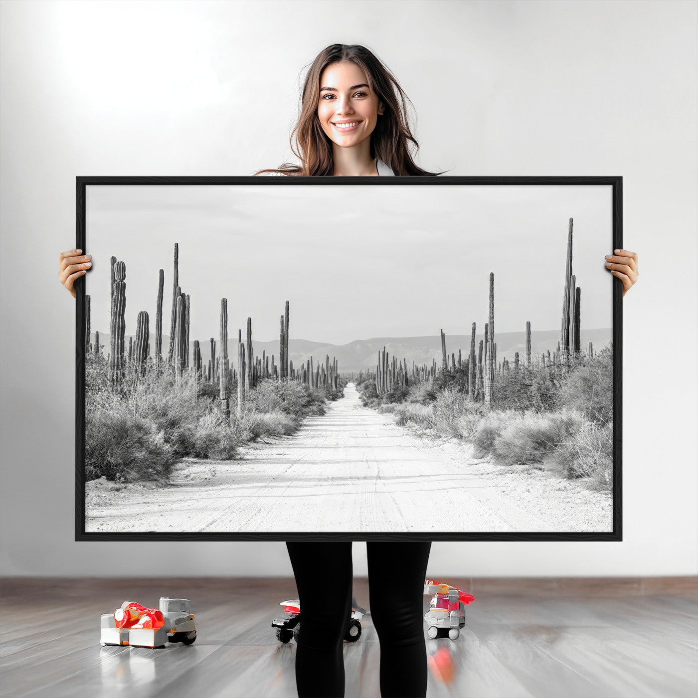 A black and white desert road stretching through a cactus-filled landscape, creating a rugged and timeless southwestern aesthetic with a sense of adventure.