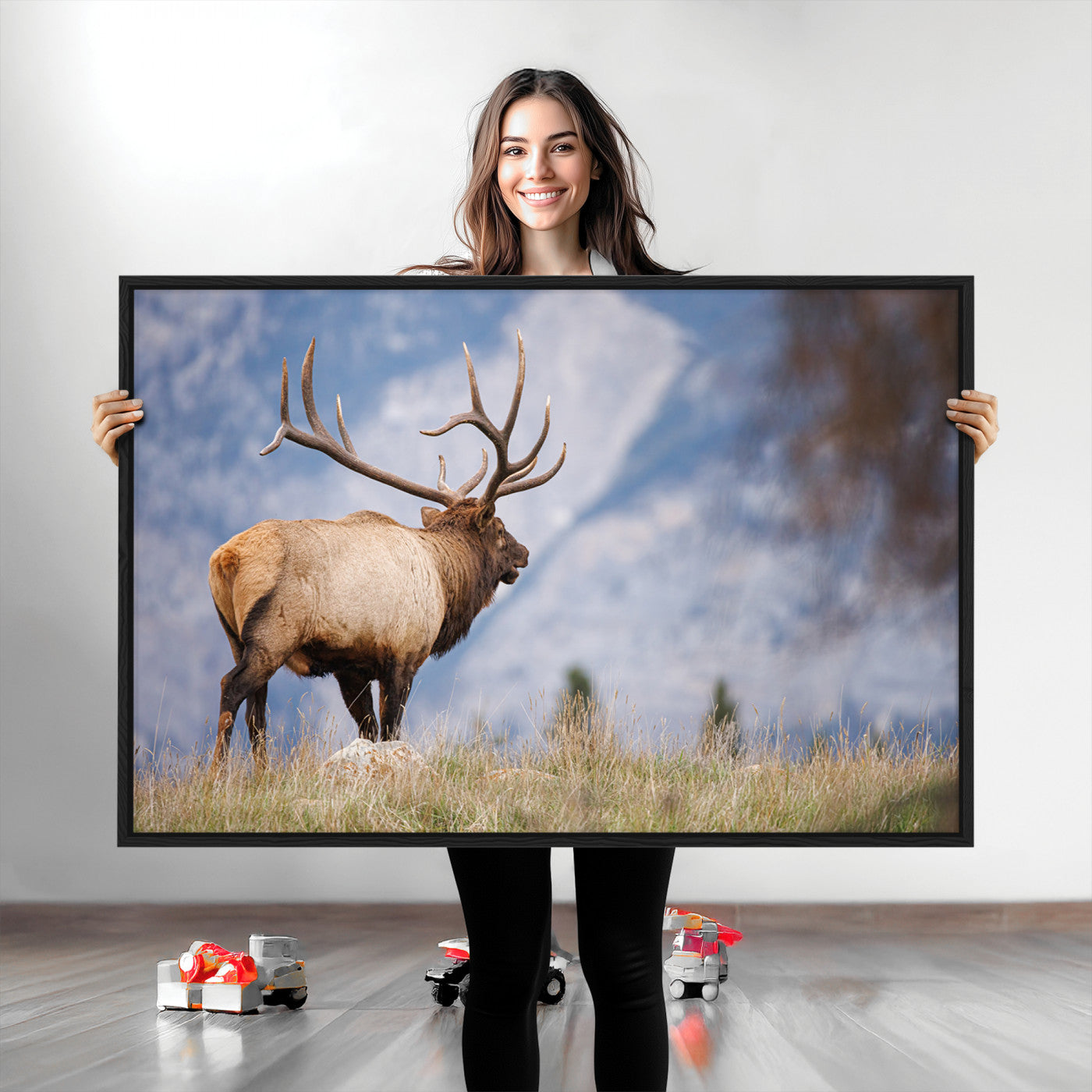 Elk with antlers standing on grass with mountain background, ideal for rustic, cabin, or lodge-inspired wall decor.