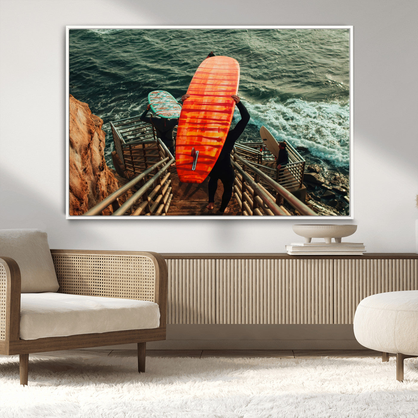 A surfer carrying a bold orange surfboard down a rugged staircase toward the ocean, bathed in golden hour light, capturing the energy of coastal adventure.
