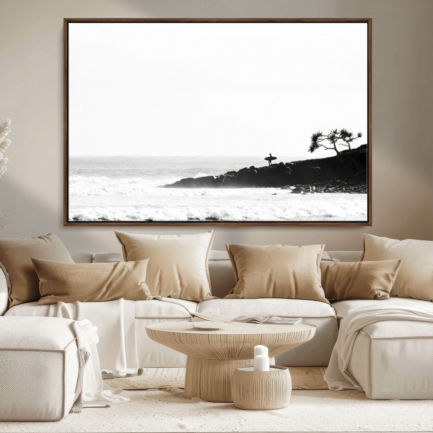 Black and white photo of a surfer standing on rocky cliffs, gazing at the waves, embodying the spirit of adventure and solitude.