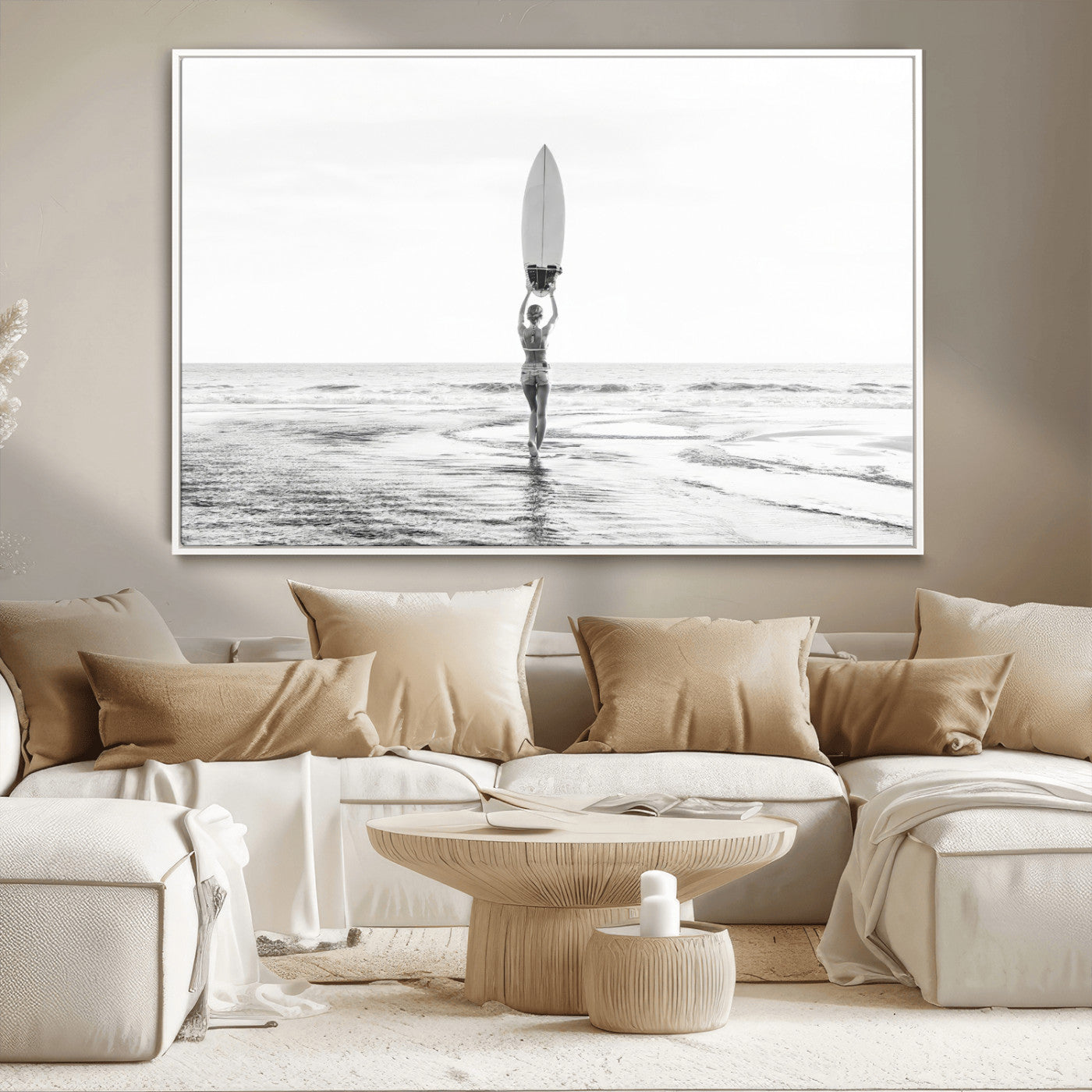 Black and white image of a female surfer holding a surfboard above her head while walking toward the ocean, creating a minimalist and bold coastal aesthetic.