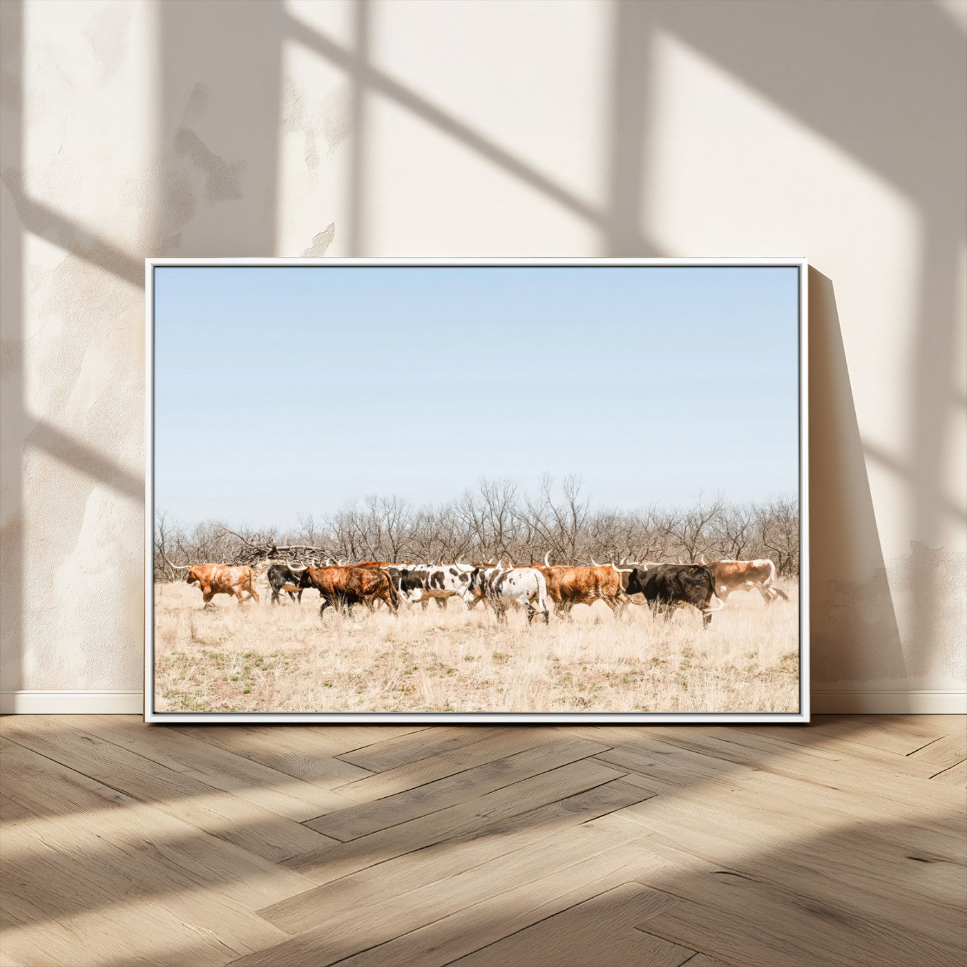 Framed wall art of Texas longhorn cattle walking through a dry, neutral-toned prairie, perfect for rustic farmhouse or western-themed home decor.