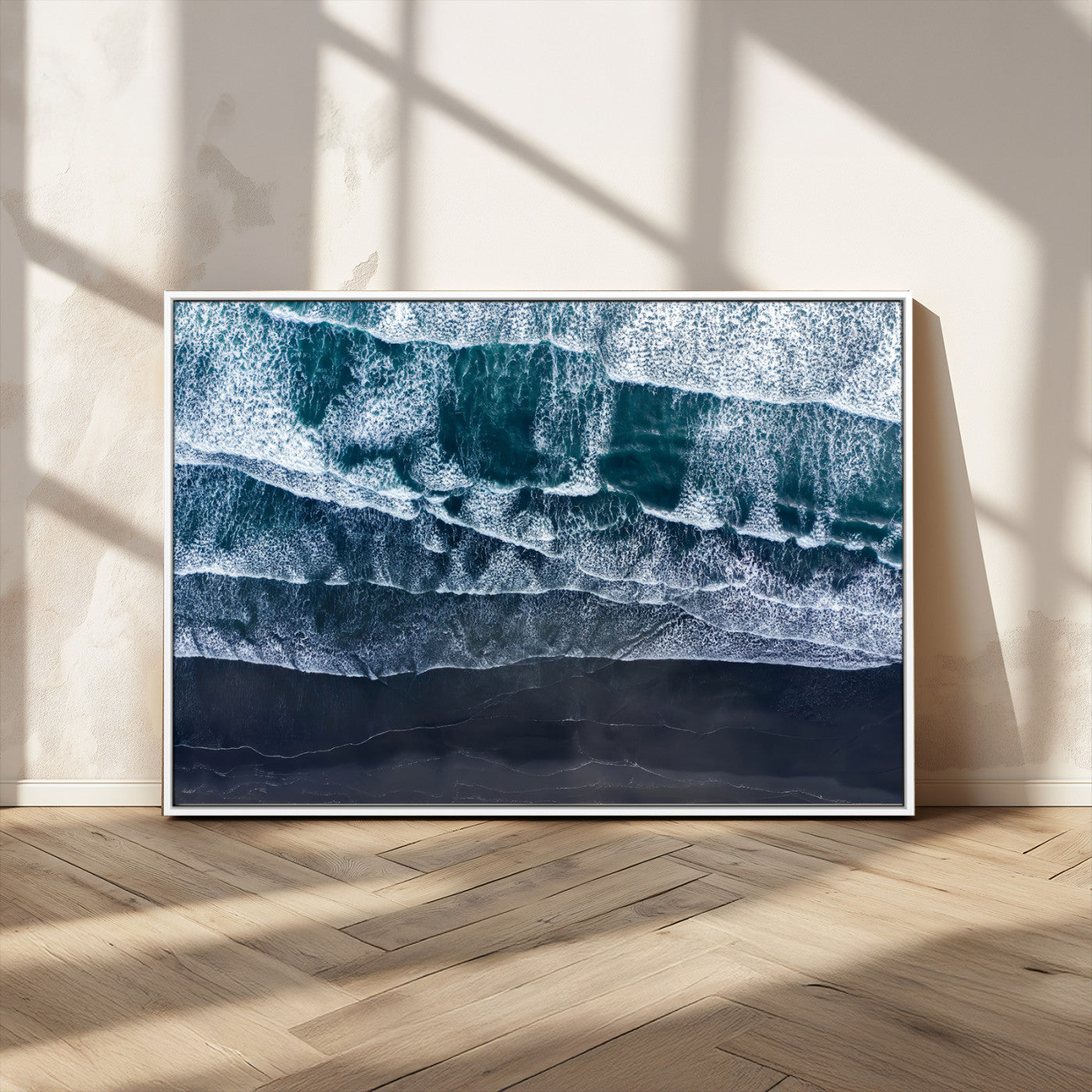 Canvas of aerial ocean waves crashing onto a black sand beach in moody tones, ideal for modern coastal or minimalist home decor.