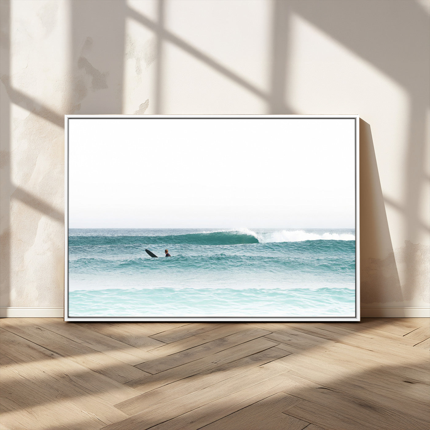Minimalist photo of a lone surfer on calm aqua waves under bright sky, perfect for Scandinavian coastal or serene ocean-inspired home decor.