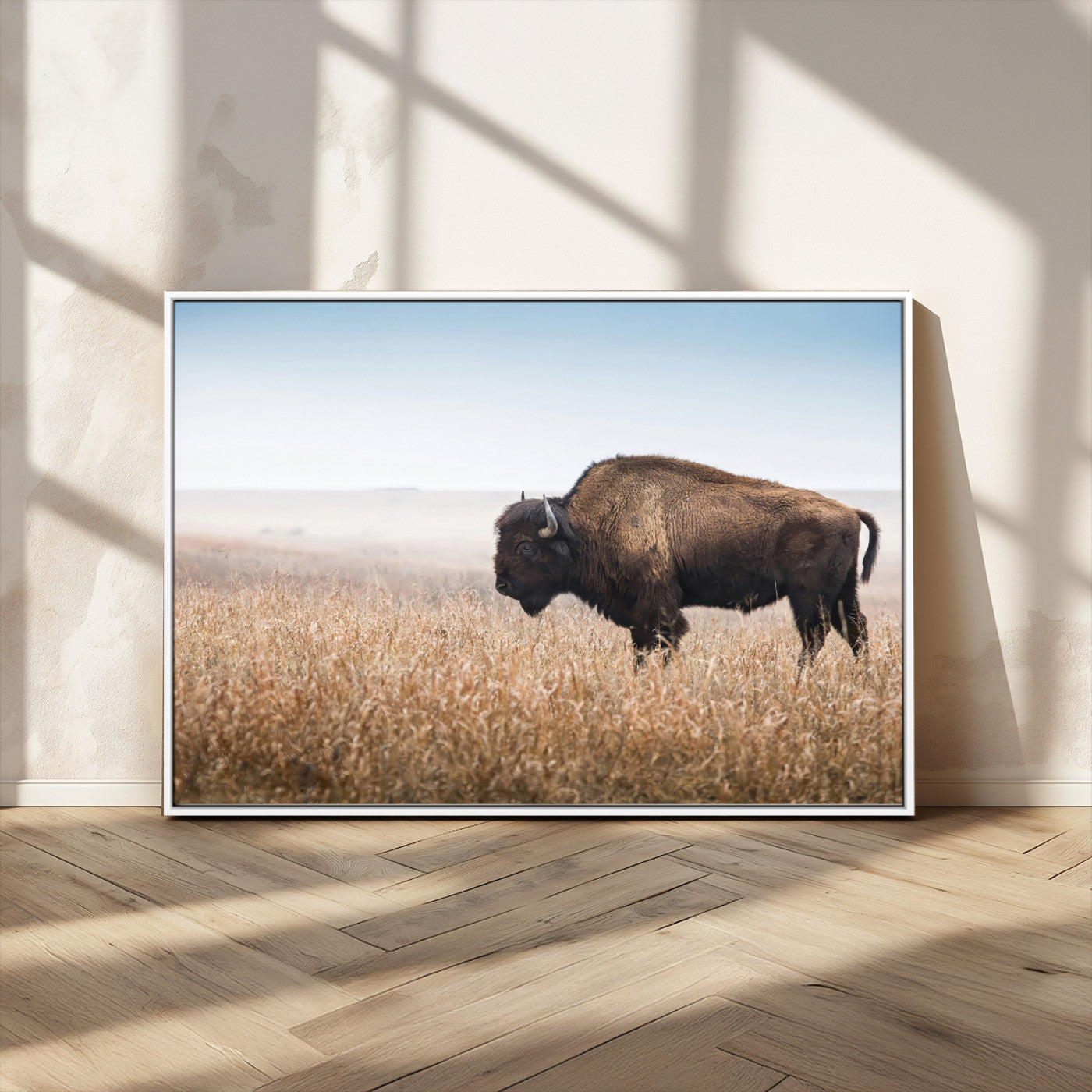 A majestic bison standing in an open prairie field, its strong form blending into the golden grass under a vast blue sky, evoking the wild spirit of the American plains.