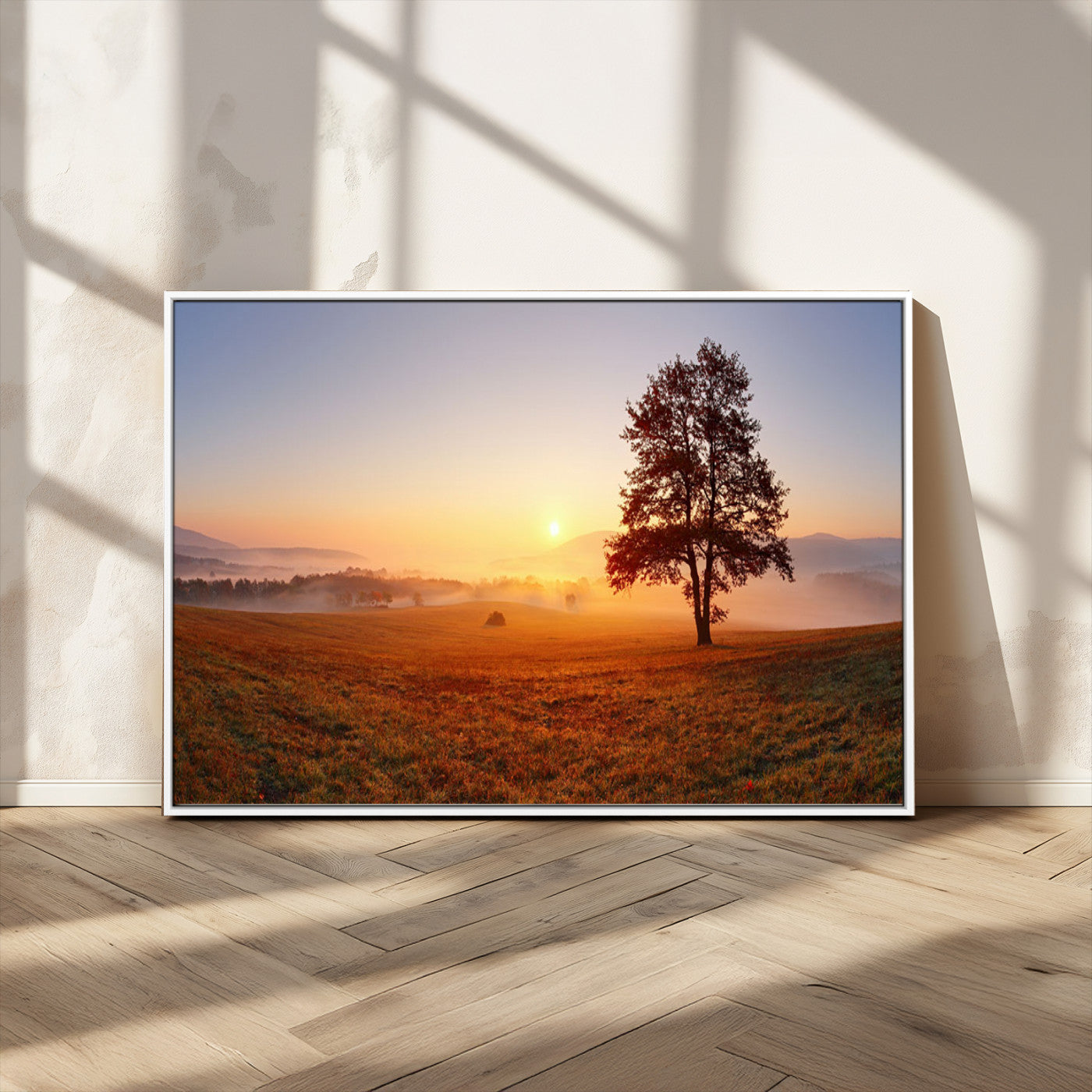 A tranquil landscape at sunrise with a mist-covered field and a lone tree, creating a peaceful and natural atmosphere.