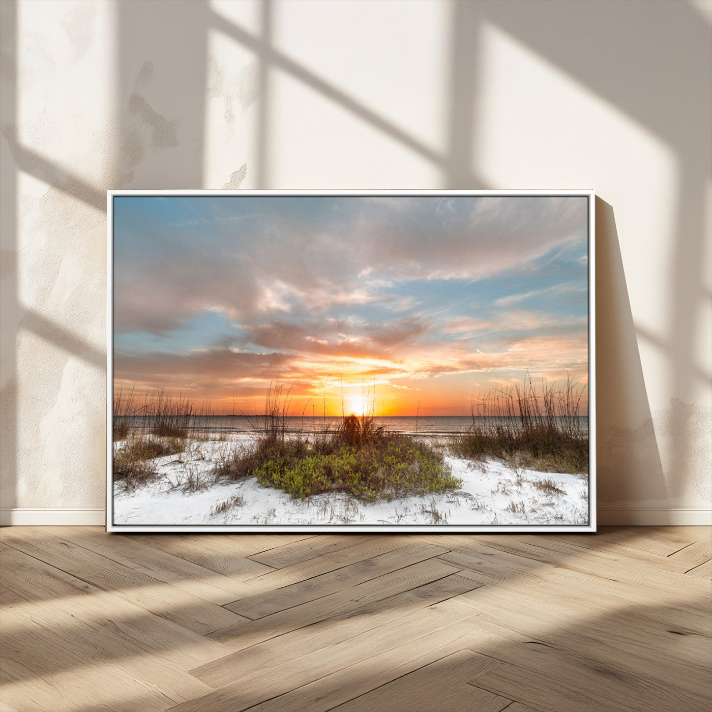 A tranquil beach scene featuring golden sunset hues over the water, with grasses in the foreground and a peaceful, serene atmosphere.