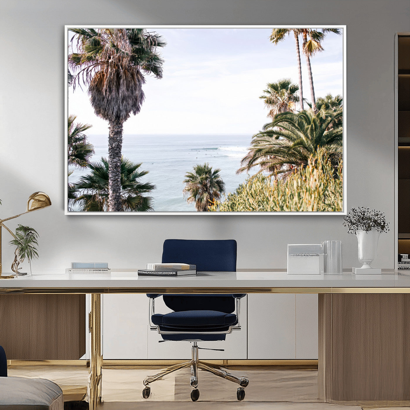 Scenic coastal view with tall palm trees overlooking a calm ocean, soft blue waves, and surfers in the distance, creating a peaceful tropical vibe.