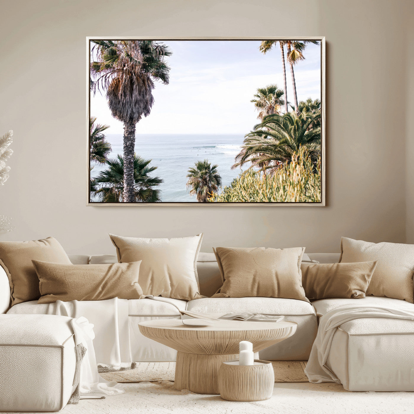 Scenic coastal view with tall palm trees overlooking a calm ocean, soft blue waves, and surfers in the distance, creating a peaceful tropical vibe.
