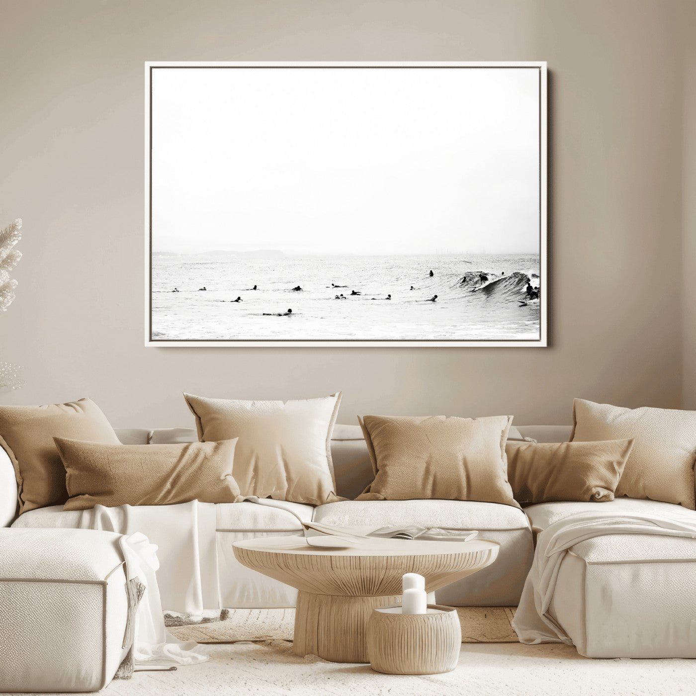 A group of surfers floating in the ocean, waiting for waves under a vast, moody sky, captured in black and white.