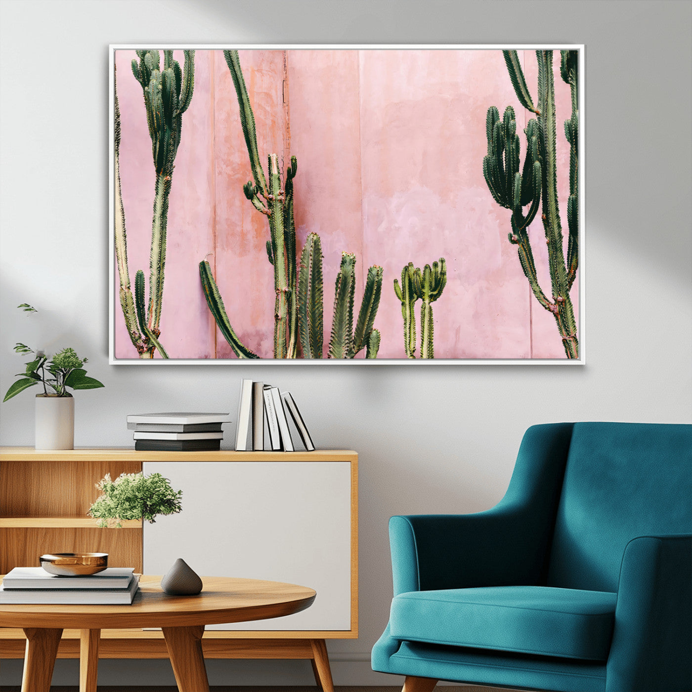 Framed canvas of tall green cacti against a soft pink wall, ideal for modern desert or colorful southwest-inspired home decor.