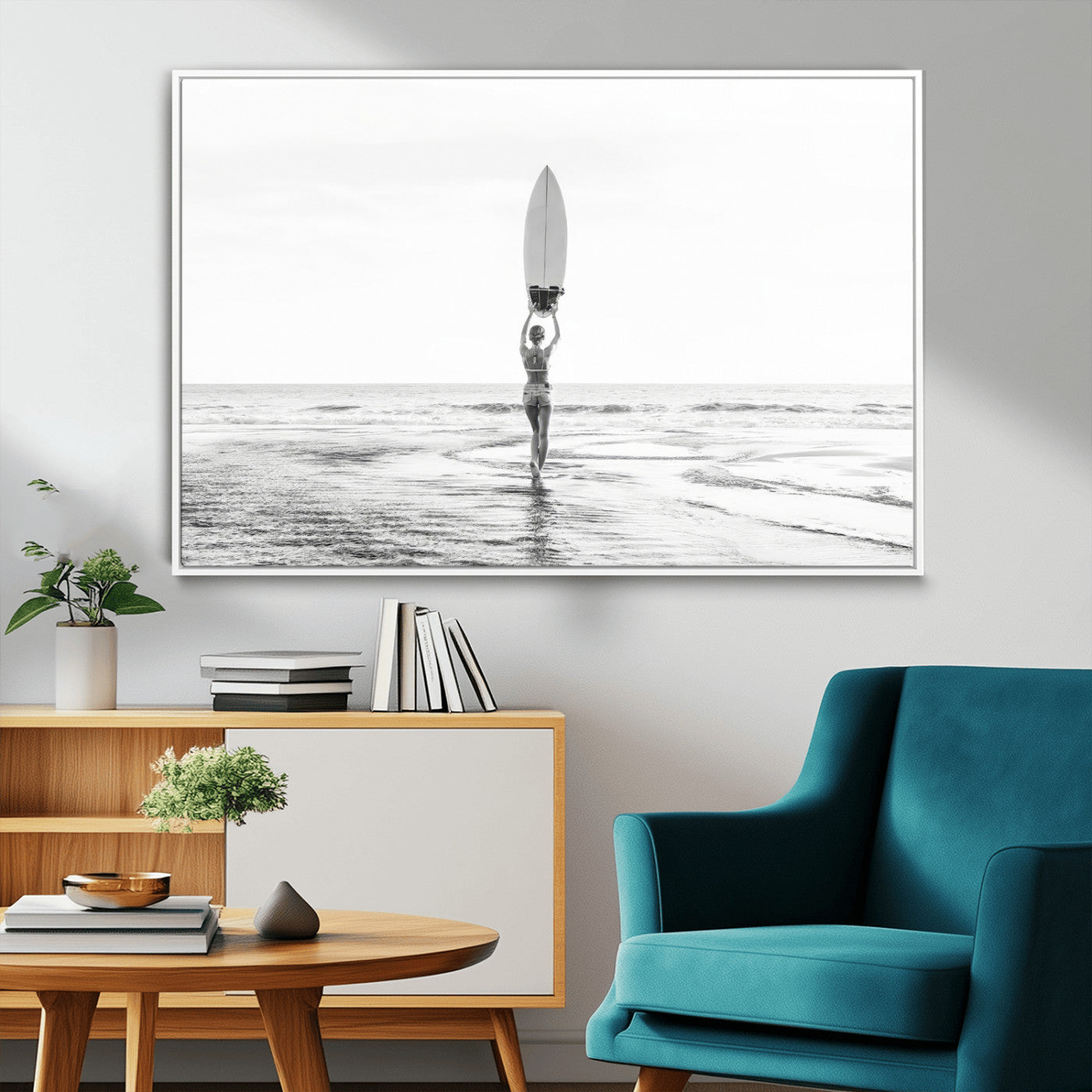 Black and white image of a female surfer holding a surfboard above her head while walking toward the ocean, creating a minimalist and bold coastal aesthetic.