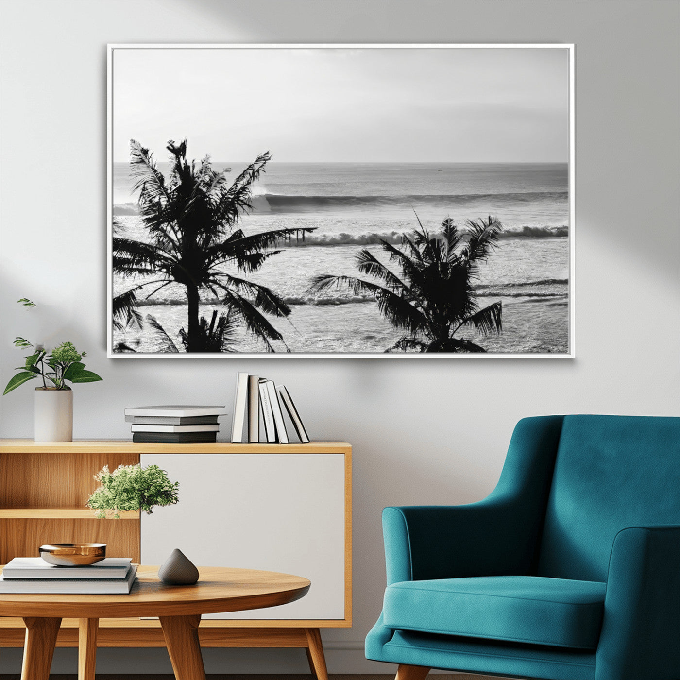 Black and white view of ocean waves crashing on a tropical coastline, framed by silhouetted palm trees under a vast, open sky.