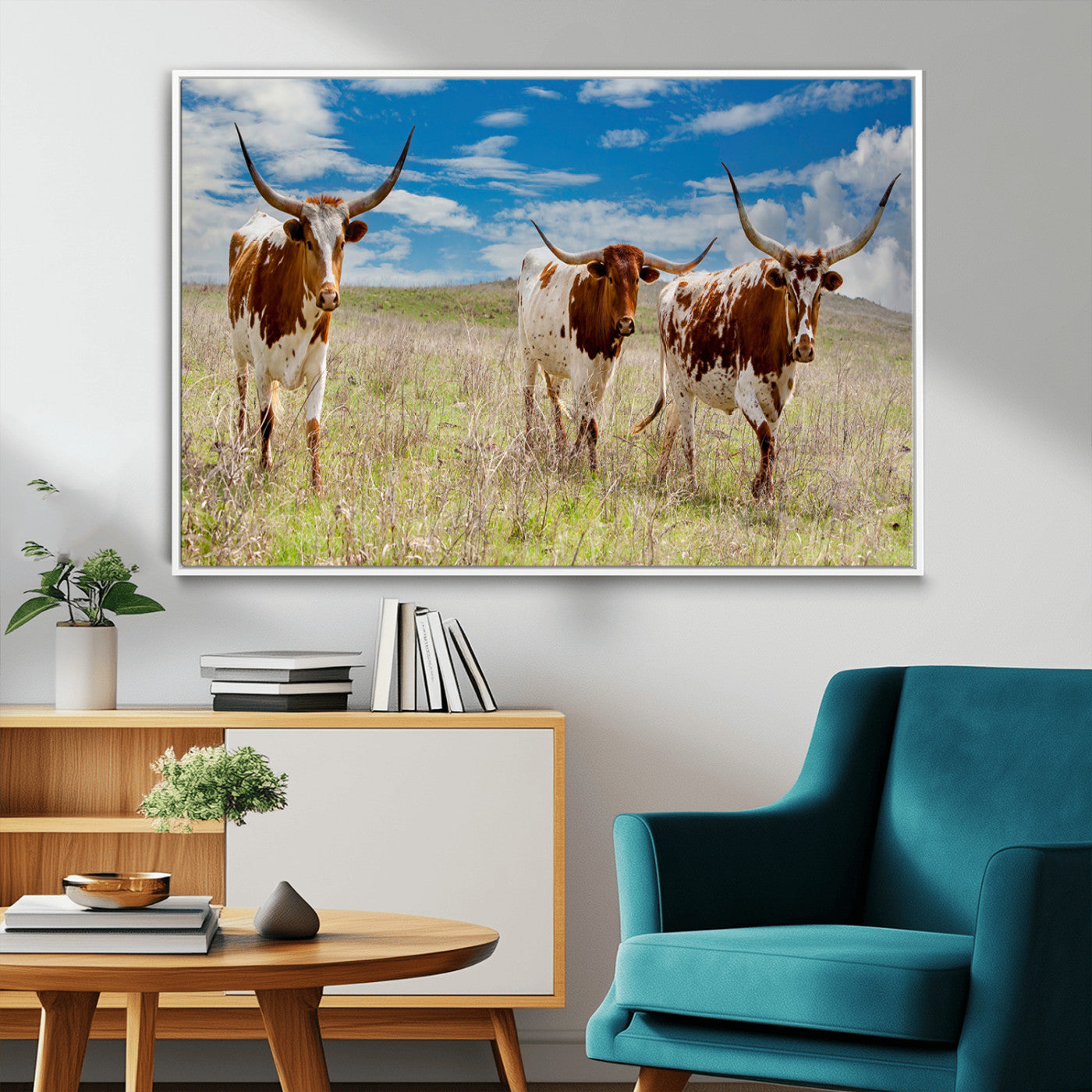 Three Texas longhorn cattle standing in dry grass under a bright blue sky, ideal for farmhouse or western rustic home decor.