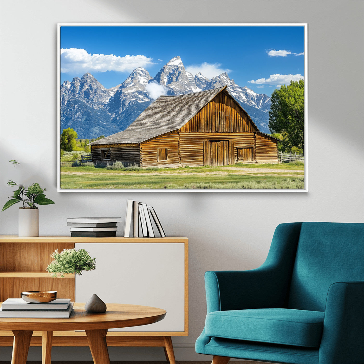 A rustic wooden barn sits in front of towering mountain peaks under a clear blue sky, perfect for farmhouse or cabin style interiors.